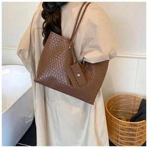 Macro detail of brown woven tote bag showing texture and matching mini pouch