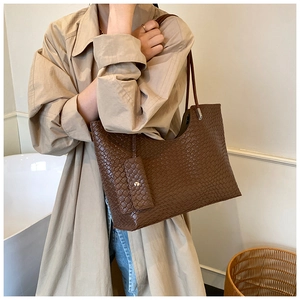 Detail shot of the woven leather texture and matching mini pouch on the large tote bag