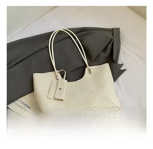 Detailed view of white woven tote bag with matching envelope pouch and slim straps