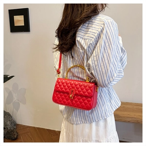 Model view of red quilted leather bag featuring a distinctive gold bamboo handle and strap