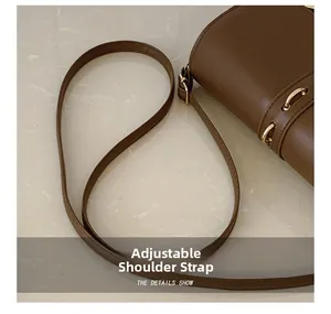 Detail of adjustable shoulder strap with gold-tone buckle on vintage brown crossbody bag