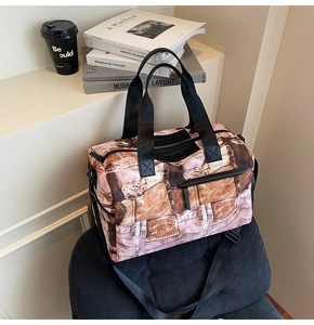 Detail der Reisetasche mit Vintage-Denim-Print, schwarzen Griffen und Seitentasche
