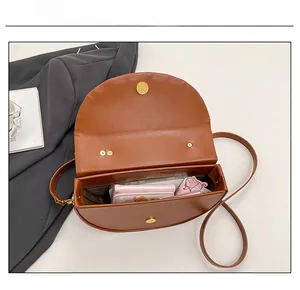Top view showing internal capacity of brown saddle bag with wallet and daily items