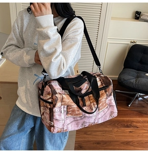 Detail einer großen Reisetasche mit Denim-Print, robusten Griffen und Seitentasche