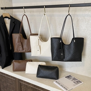 Three woven tote bags with matching pouches in black, off-white, and brown colors