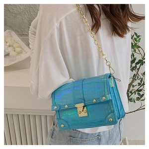 Detail of blue laser-effect crossbody bag with crocodile texture and gold hardware