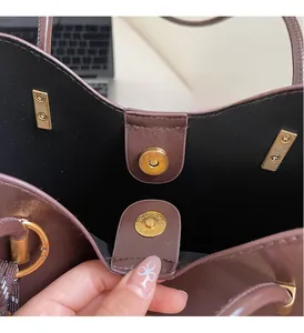 Detail of high-quality golden magnetic hardware and leather texture on a retro tote bag
