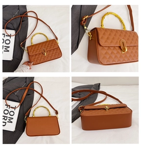 Detail view of brown quilted crossbody bag featuring golden bamboo handle and lock