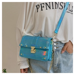 Detail of holographic blue crocodile texture and gold metal buckle on a shoulder bag