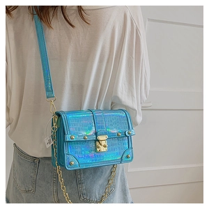 Detail of laser iridescent blue crossbody bag with crocodile texture and gold clasp