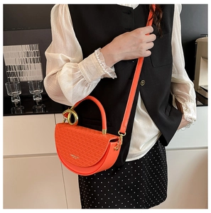 Orange half-moon crossbody bag with letter texture and golden ring handle on model