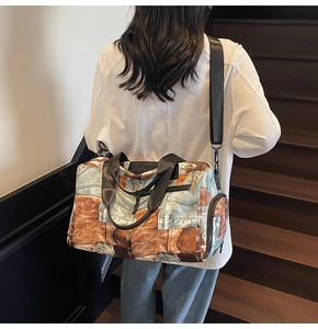 Detail der Vintage-Reisetasche mit Denim-Print, Griffen und verstellbarem Gurt