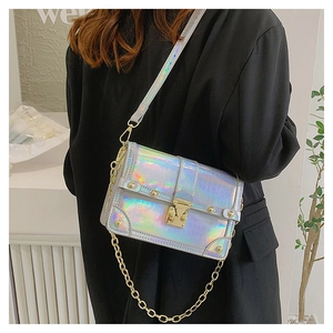 Detailed close-up of holographic crossbody bag with crocodile pattern and gold hardware
