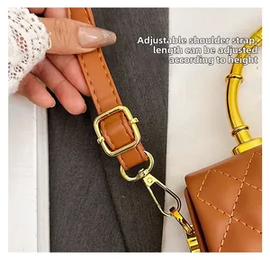 Detail of adjustable leather strap and golden buckle on brown quilted box bag