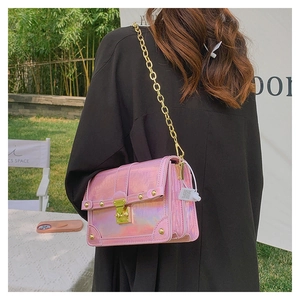 Detail of holographic pink crossbody bag with crocodile pattern and golden metal clasp