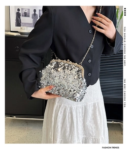 Close-up of shimmering silver sequin evening bag with gold metal frame and pearl clasp