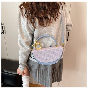 Detail of the saddle bag showing the light purple contrast and golden metal ring accents