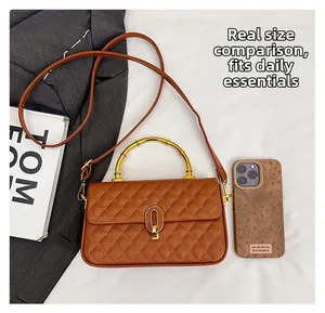Brown quilted crossbody bag with bamboo metal handle shown next to a smartphone for scale