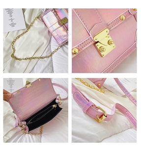 Detail view of pink laser crocodile texture crossbody bag with gold lock and chain strap