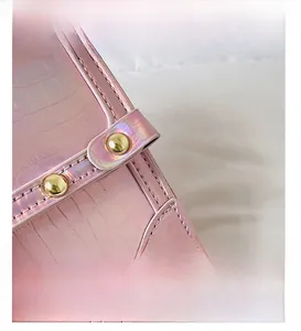 Detail of pink laser hologram crocodile pattern bag with golden metallic rivets