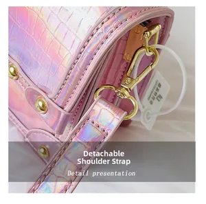 Close-up of iridescent pink croc-effect bag showing detachable gold lobster clasp strap