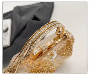 Macro detail of golden handle with crystal rhinestones on luxury sequin evening clutch bag