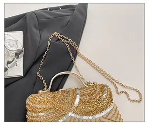 Macro detail of wave-patterned gold beads, white pearls and silver sequins on evening bag