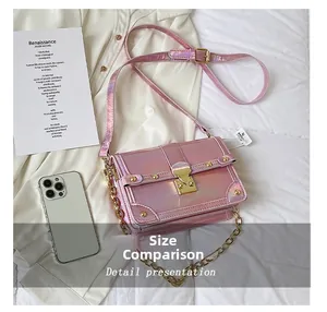 Detail of holographic pink crossbody bag with golden S-lock closure and chain strap