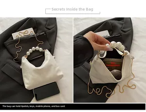 Detail view of pearl handle bag interior showing space for phone and makeup