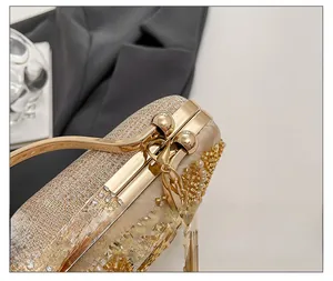 Macro view of champagne gold evening bag with hand-sewn beads and golden ball clasp