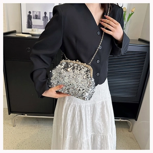 Detail of silver sequined shell bag with gold chain and pearl frame on model