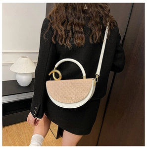 Detail of a half-round beige handbag with khaki woven flap and gold metal ring handle