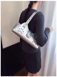 Silver punk shoulder bag with rivets shown worn by a model in a trendy street style look
