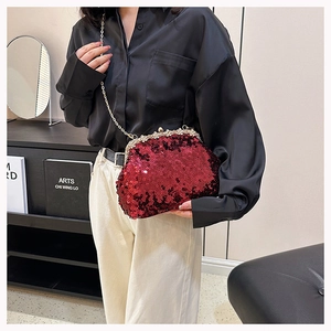 Detail of burgundy sequin evening bag with gold flower clasp and chain strap