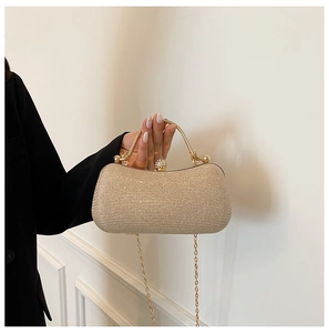 Détail du sac de soirée pailleté avec poignée ronde dorée et fermoir bijou sphérique