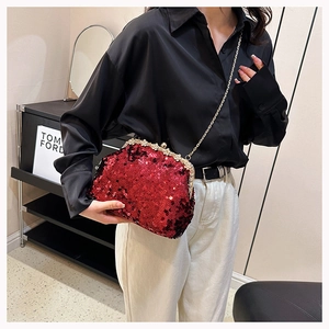 Close-up of red sequined clutch with rhinestone edges and golden chain for evening dress