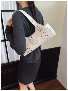 Beige matte leather underarm bag with silver studs and wide shoulder strap