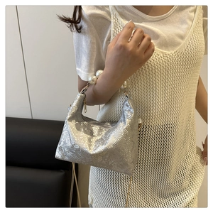 Detail of silver snake-pattern shoulder bag with elegant large pearl chain handle strap