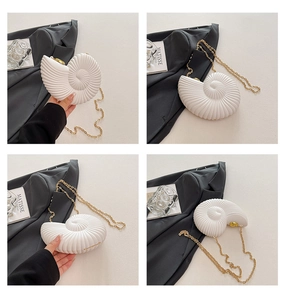 Macro detail of conch-shaped acrylic handbag featuring realistic spiral textures and gold clasp