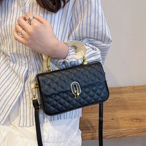 Classic black quilted crossbody box bag with gold metal handle and leather shoulder strap