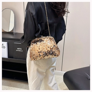 Detail of a golden sequin shell bag featuring a delicate metal chain for evening wear