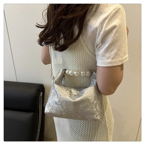 Detail of silver snake pattern texture handbag with large pearl handle and metal chain strap