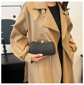Détail du sac de soirée noir pailleté avec poignée en métal doré et bandoulière