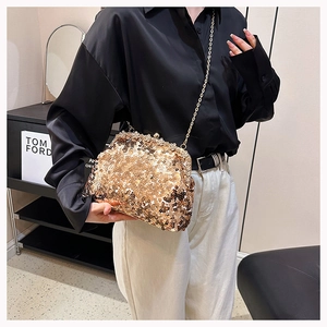 Close-up of luxury gold sequin evening bag with elegant metal chain strap for women