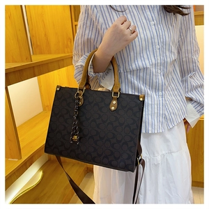 Detail of the vintage monogram tote bag featuring leather handles and shoulder strap