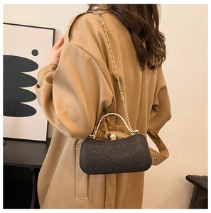 Détail du sac de soirée noir pailleté avec poignée anneau dorée et fermoir boule en cristal