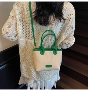Detail of canvas bucket bag with green leather trim and stylish knotted handle