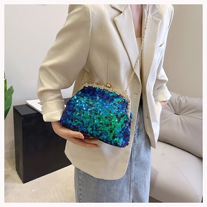 Close-up of sequined shell evening bag with gold chain strap on a stylish model