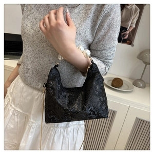 Detail of snake pattern leather dumpling bag with pearl handle and gold chain strap