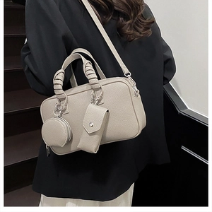 Detail view of elephant gray lychee leather Boston bag with 3-in-1 accessory pouches